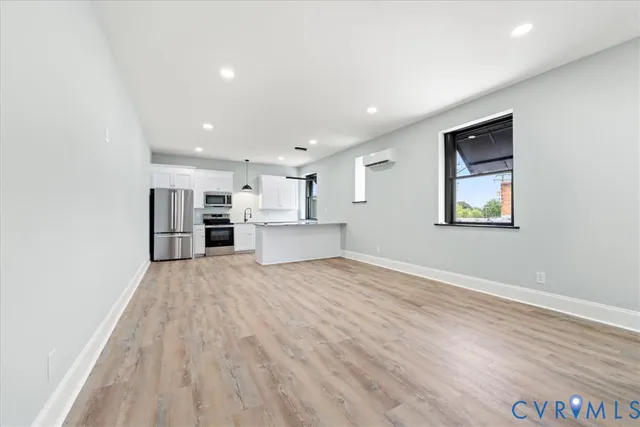 a view of empty room with wooden floor