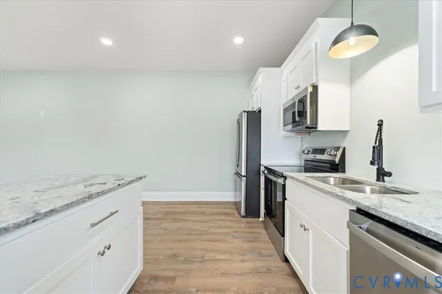 a kitchen with a sink dishwasher a stove and a refrigerator with wooden floor