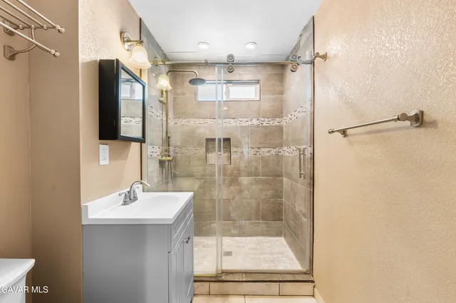 a bathroom with a shower sink and mirror