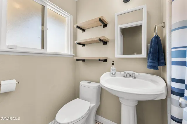 a bathroom with a sink a toilet and mirror