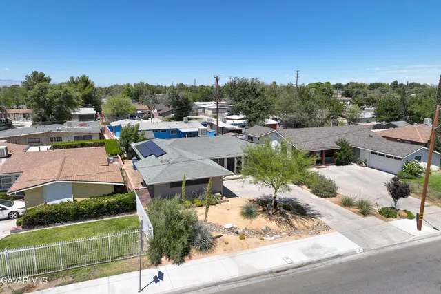 a view of a houses with a yard and potted plants