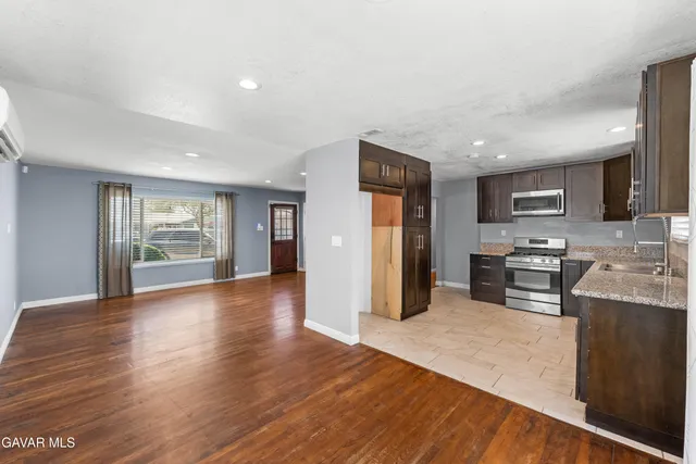 a kitchen with stainless steel appliances granite countertop a refrigerator and a stove top oven