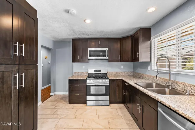 a kitchen with stainless steel appliances granite countertop a stove sink and cabinets
