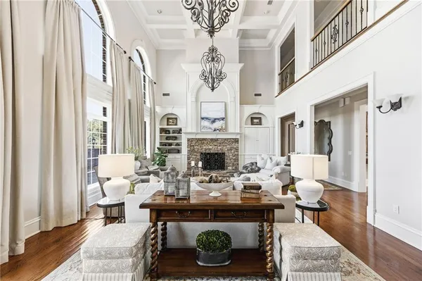 a kitchen with stainless steel appliances granite countertop a refrigerator a sink dishwasher a stove and a dining table with wooden floor