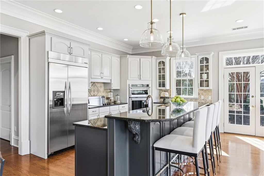1400 Paul Aiken Road Dallas, GA 30157 - Photo 20 of 62 a kitchen with stainless steel appliances granite countertop a refrigerator a sink dishwasher a stove and a dining table with wooden floor