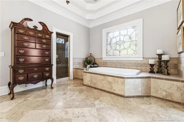 a bedroom with a large bed and a chandelier