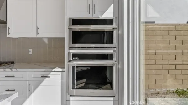 a kitchen with granite countertop white cabinets and white appliances