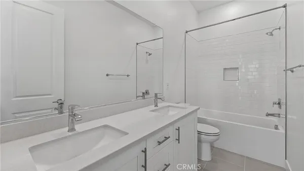 a bathroom with a granite countertop sink a toilet and shower