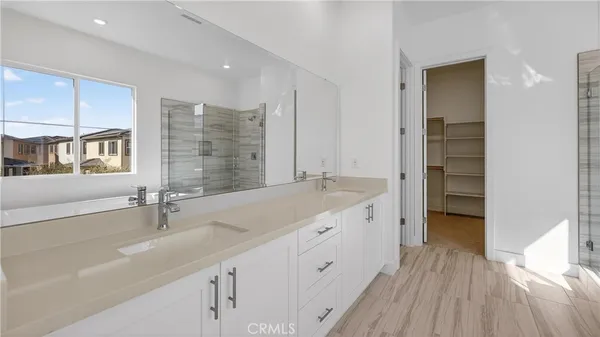 a bathroom with a double vanity sink a mirror and a bathtub