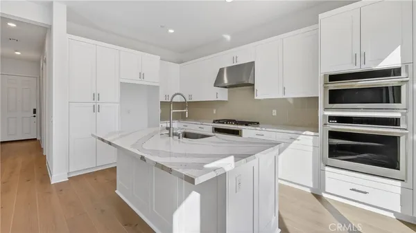 a kitchen with appliances a sink and cabinets