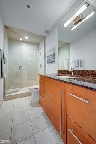 a bathroom with a granite countertop sink a toilet and shower