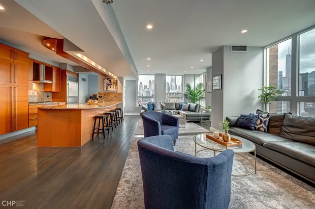 a living room with stainless steel appliances kitchen island granite countertop wooden floor a dining table and chairs