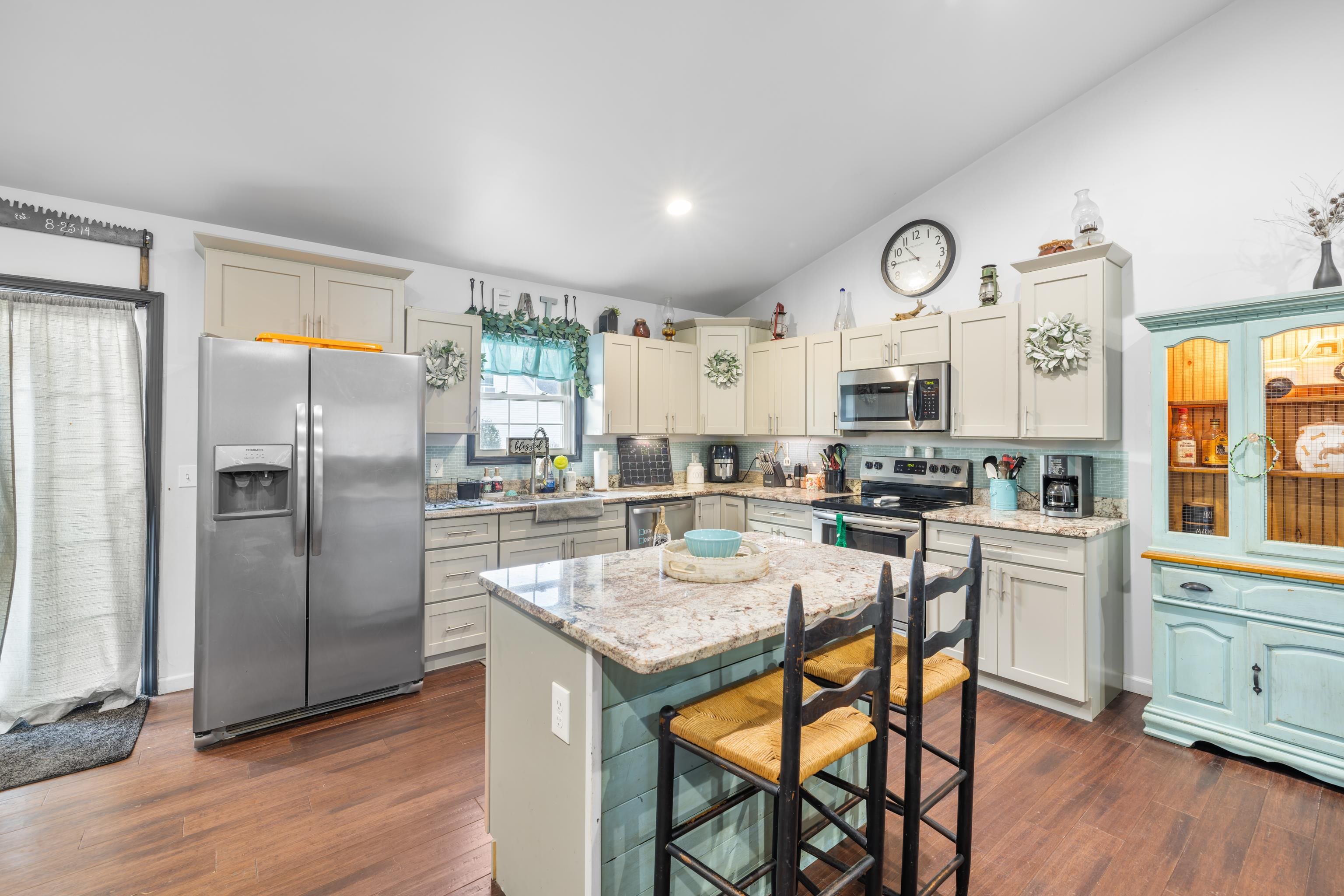 703 14th Street Grottoes, VA 24441 - Photo 8 of 51 a kitchen with stainless steel appliances granite countertop a refrigerator a stove a sink a dining table and chairs with wooden floor