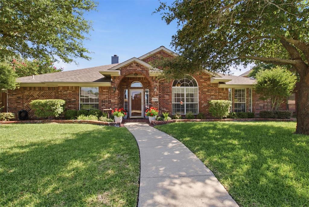 4218 Glistening Spring Rowlett, TX 75088 - Photo 2 of 39 Brick exterior residence with a curved entry walkway, arched front door, and an arched window featuring grid patterns