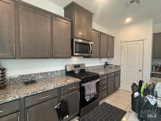 a kitchen with granite countertop a sink stove and refrigerator