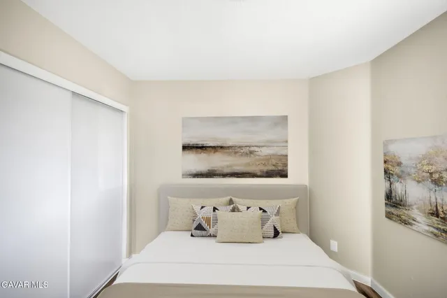 a bedroom with a bed and a painting on the wall