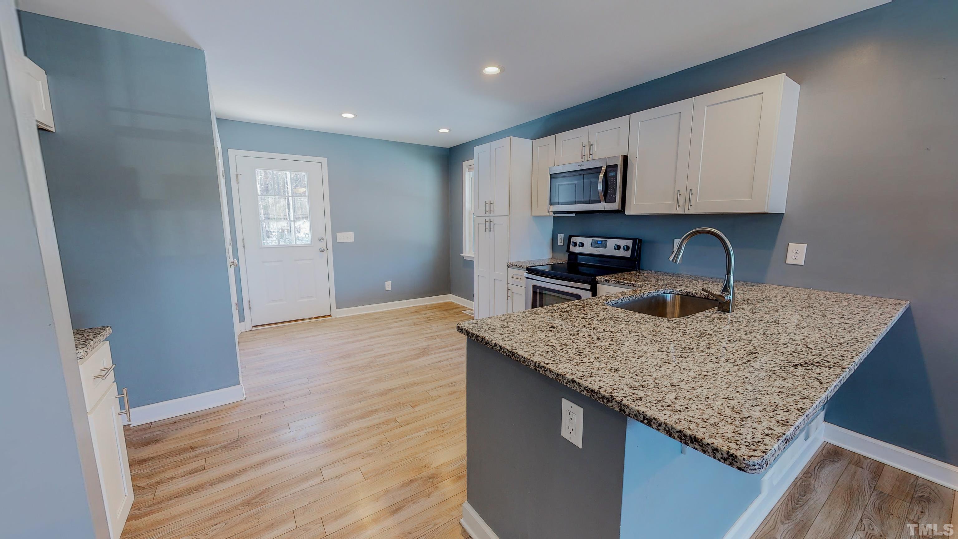 45 Eli Court Roxboro, NC 27573 - Photo 26 of 36 a kitchen with stainless steel appliances granite countertop a sink dishwasher and cabinets with wooden floor