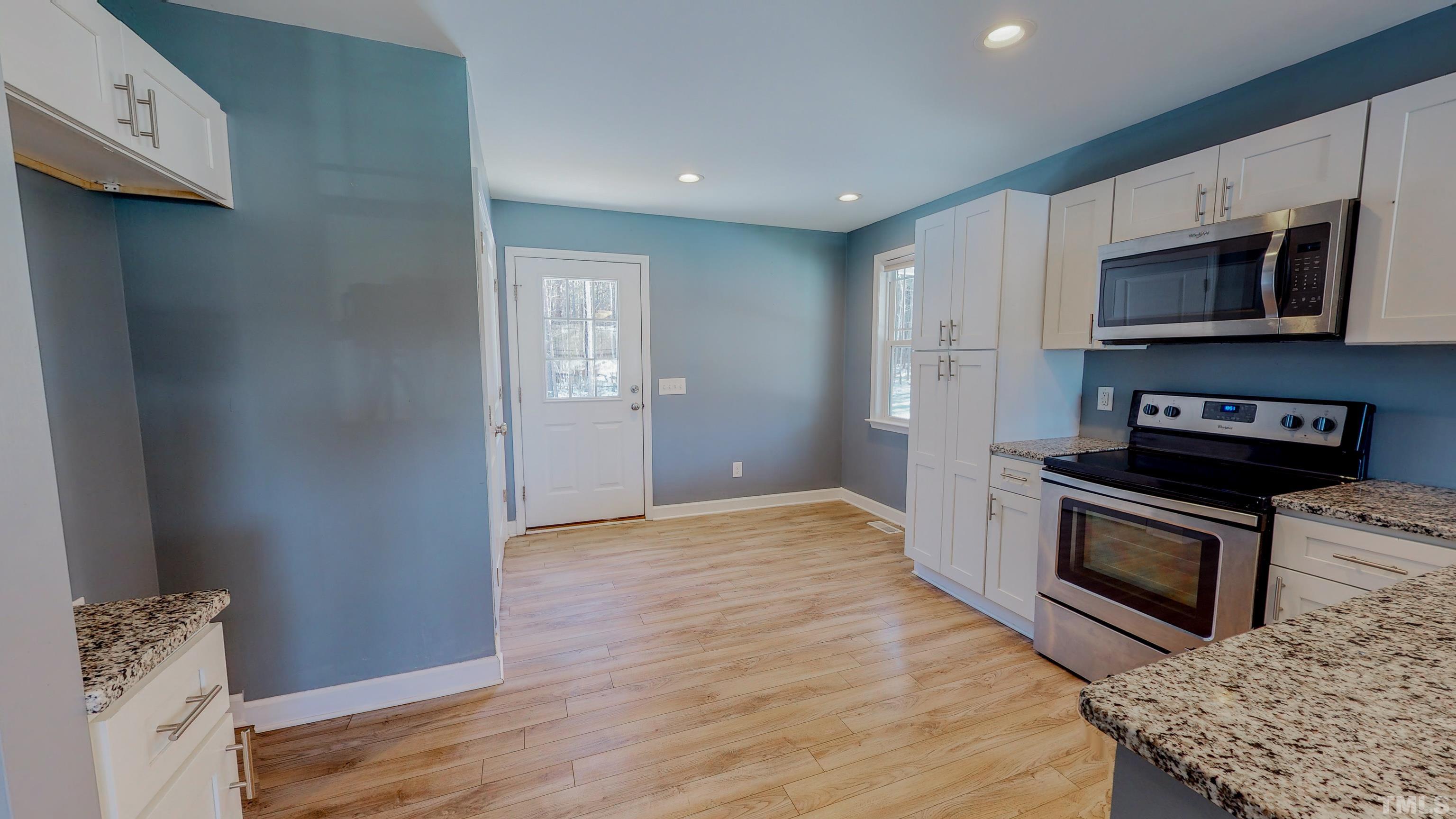 45 Eli Court Roxboro, NC 27573 - Photo 28 of 36 a kitchen with stainless steel appliances granite countertop a stove a microwave and a refrigerator