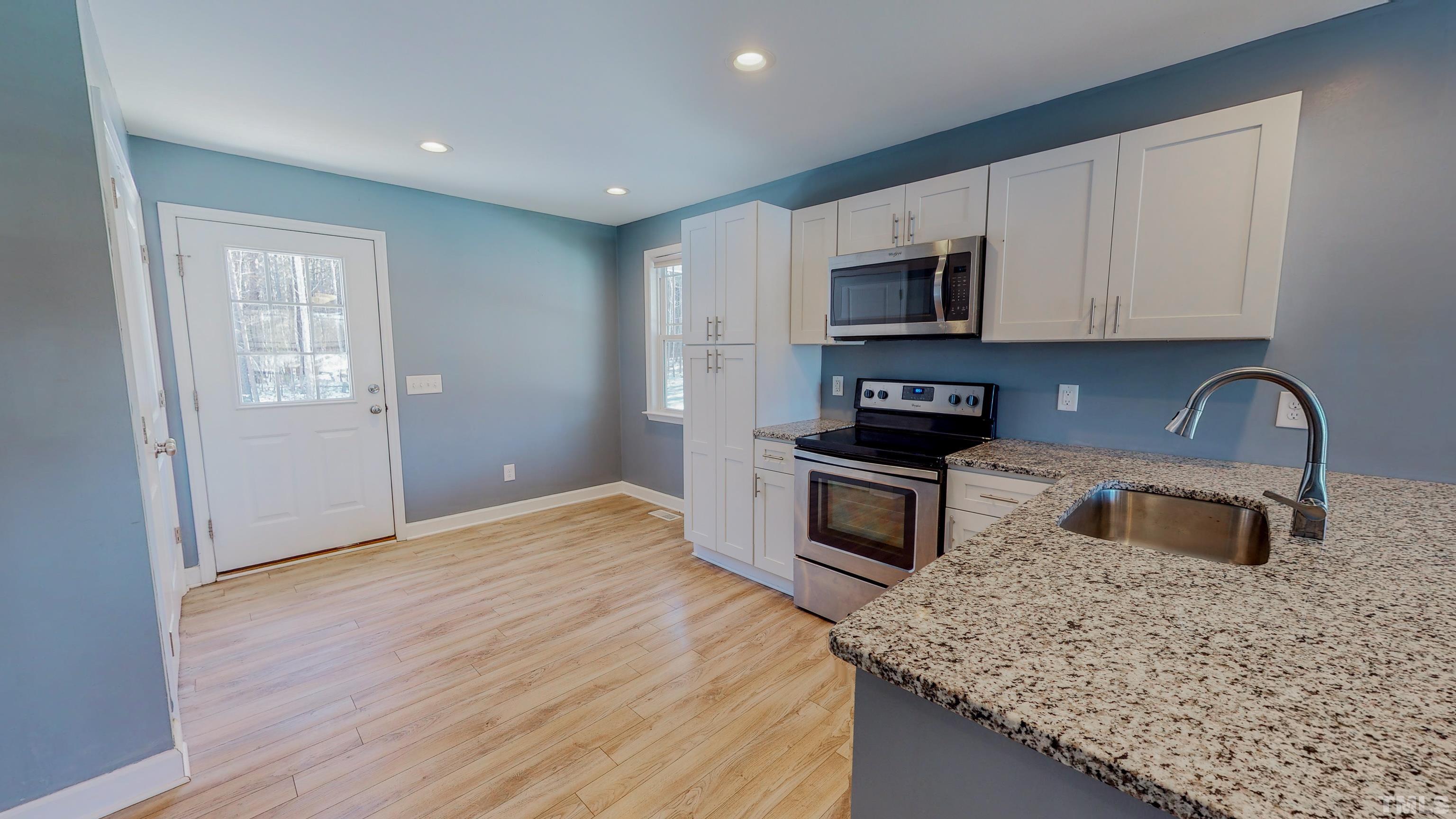 45 Eli Court Roxboro, NC 27573 - Photo 7 of 36 a kitchen with granite countertop white cabinets and stainless steel appliances