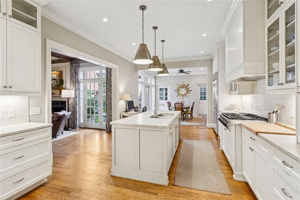 3005 Ranch Road Southeast Atlanta, GA 30339 - Photo 24 of 57 a large kitchen with stainless steel appliances kitchen island granite countertop a stove a refrigerator a sink dishwasher and white cabinets with wooden floor