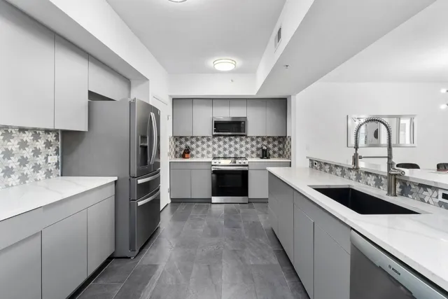 a kitchen with a sink cabinets and stainless steel appliances