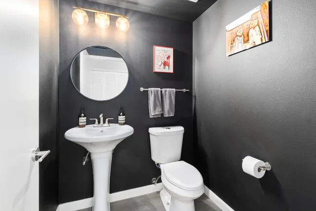a bathroom with a toilet sink and mirror