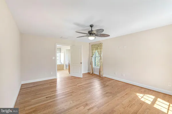 a view of a house with a small yard and large trees