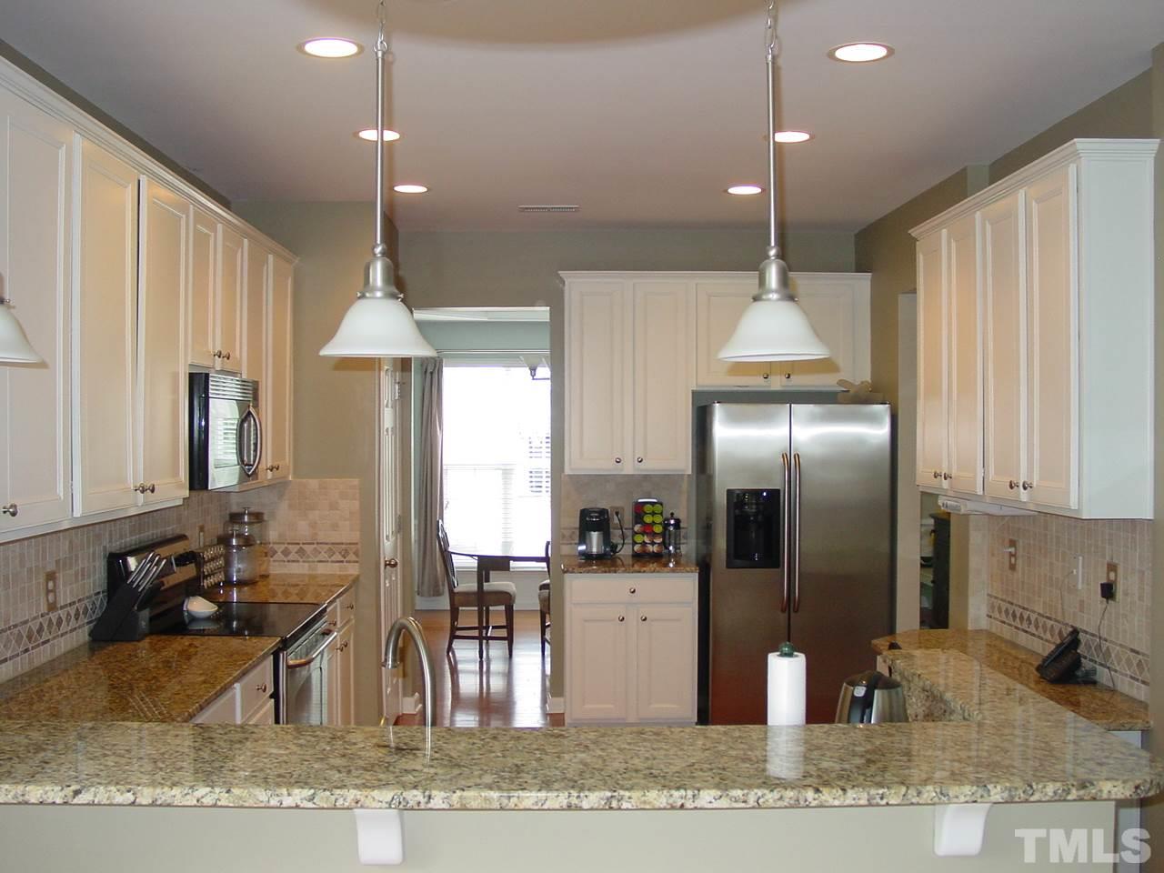 7724 Jackson Dane Drive Raleigh, NC 27613 - Photo 4 of 25 Granite, hardwoods, 42" cabinets, tile backsplash, built in desk, pantry, breakfast bar and stainless appliances.
