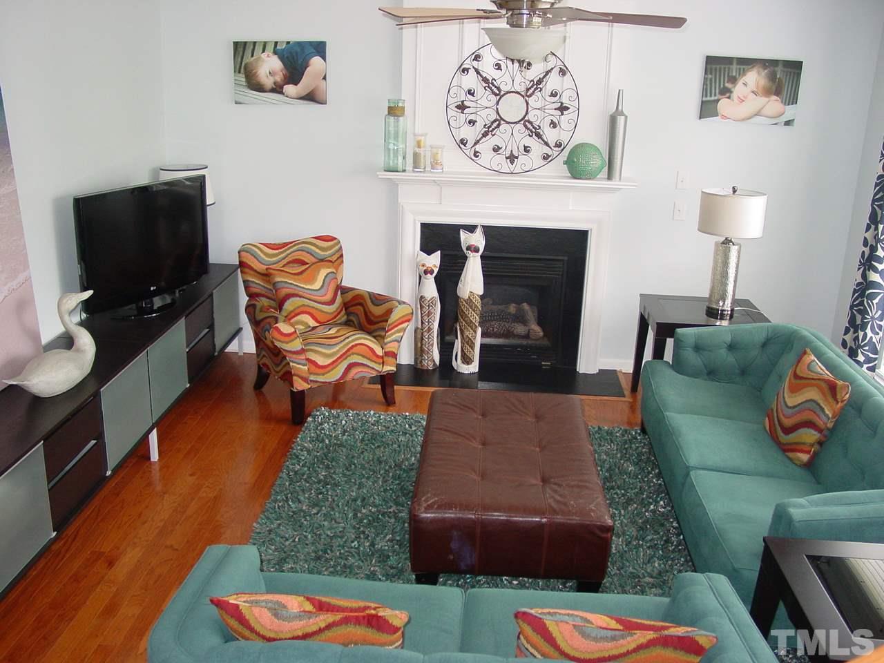 7724 Jackson Dane Drive Raleigh, NC 27613 - Photo 8 of 25 Hardwood floors, gas log fireplace, and wall of windows