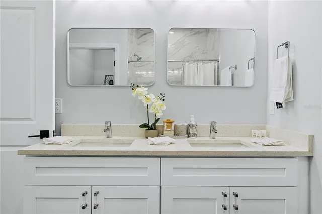 a bathroom with double vanity sinks and a mirror
