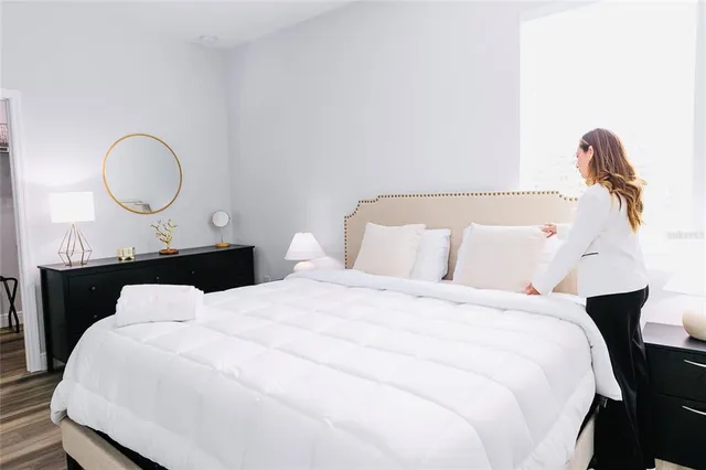 a bedroom with bed and wooden floor