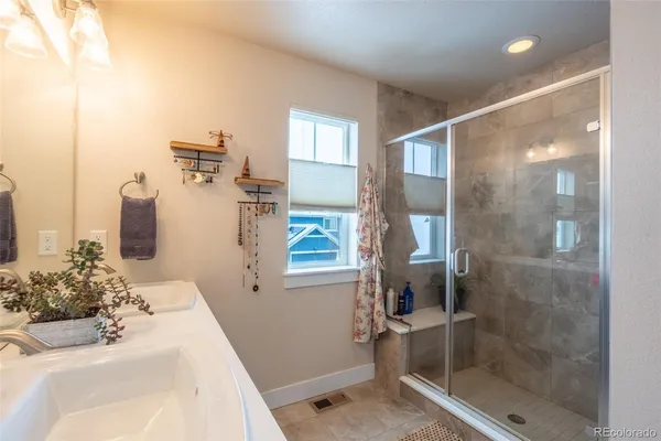 a bathroom with a double vanity sink a mirror and a shower