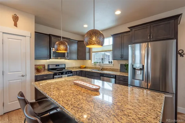 a kitchen with granite countertop a center island and stainless steel appliances