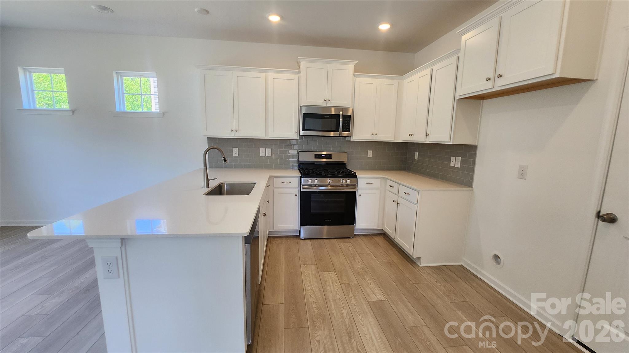 7002 Juneberry Way Maiden, NC 28650 - Photo 3 of 25 a kitchen with granite countertop a stove top oven a sink a counter space and cabinets