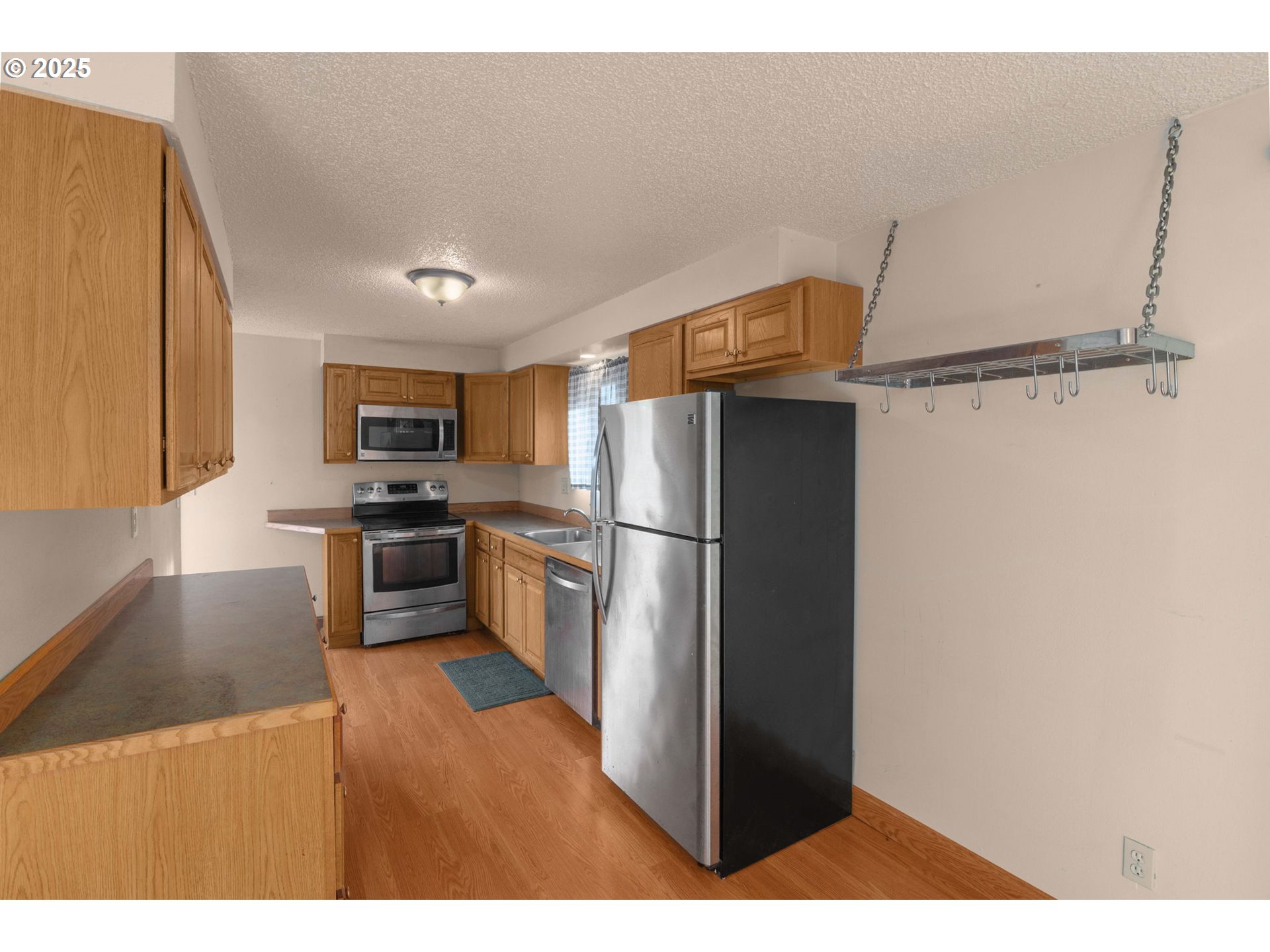 32198 Cater Road Warren, OR 97053 - Photo 29 of 48 a kitchen with refrigerator cabinets and wooden floor
