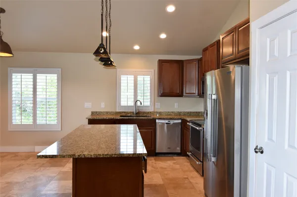 a view of an empty room and kitchen view