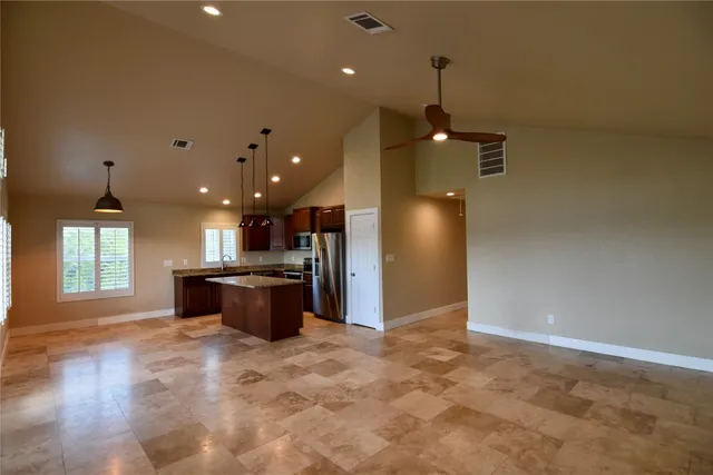 a kitchen with stainless steel appliances granite countertop a sink a refrigerator and a stove