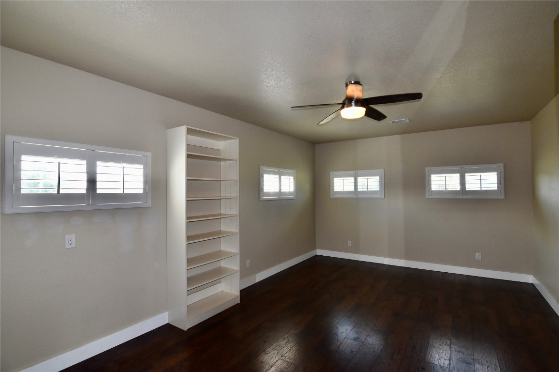 112 Ridge Harbor Drive Spicewood, TX 78669 - Photo 20 of 40 an empty room with wooden floor chandelier fan and windows
