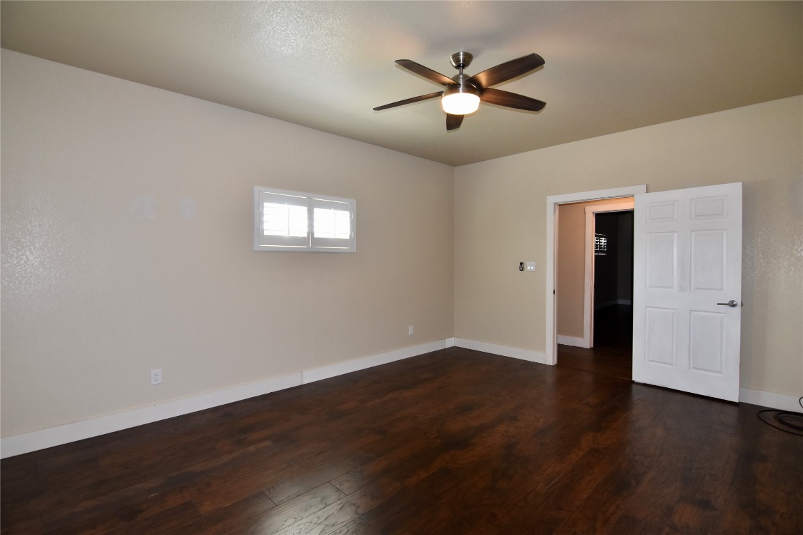 112 Ridge Harbor Drive Spicewood, TX 78669 - Photo 21 of 40 a view of an empty room with wooden floor and a ceiling fan