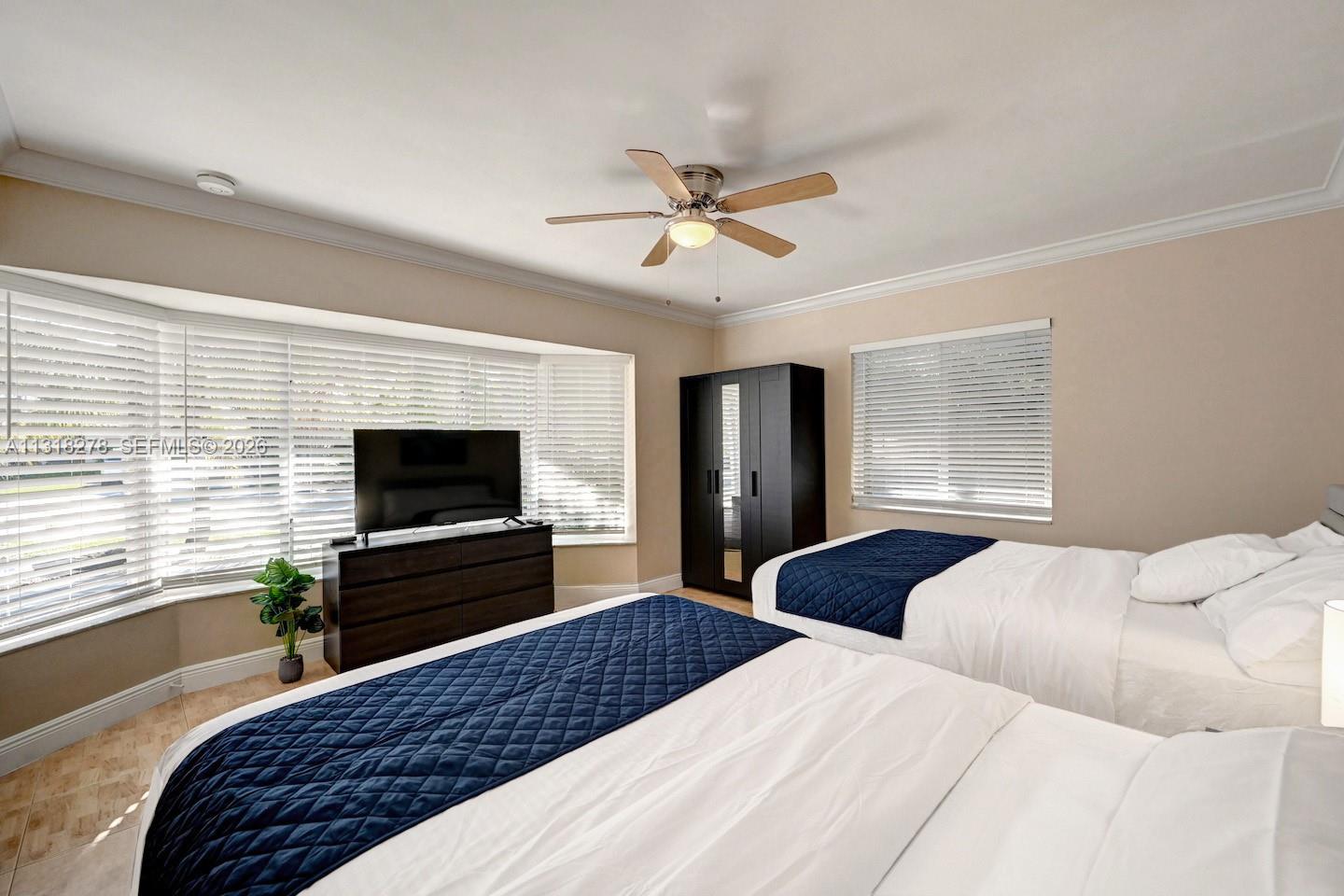 825 Harrison Street Hollywood, FL 33019 - Photo 14 of 37 a bedroom with a bed and a flat screen tv