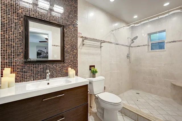 a bathroom with a sink toilet a mirror and shower