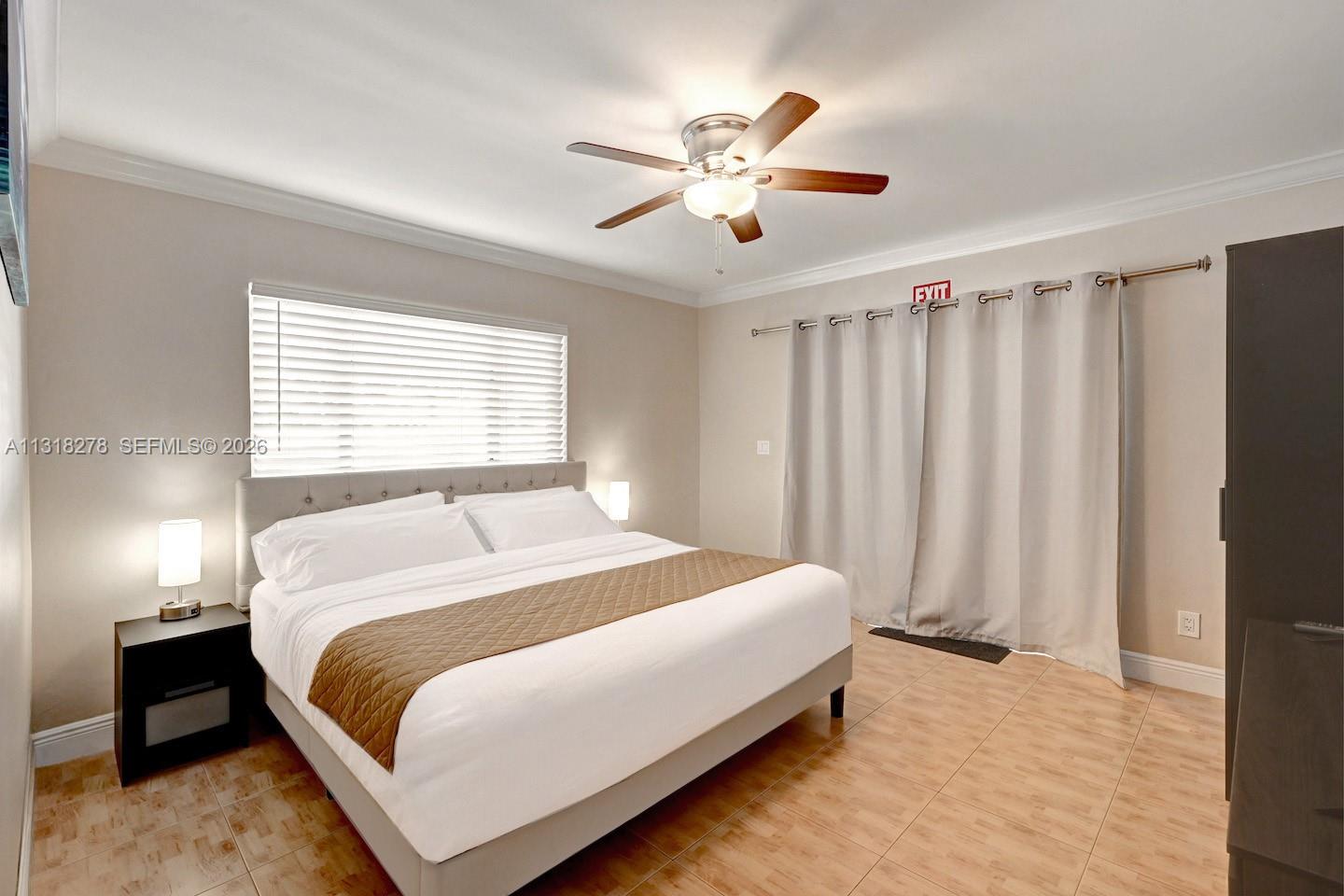 825 Harrison Street Hollywood, FL 33019 - Photo 24 of 37 a bedroom with a large bed and a chandelier