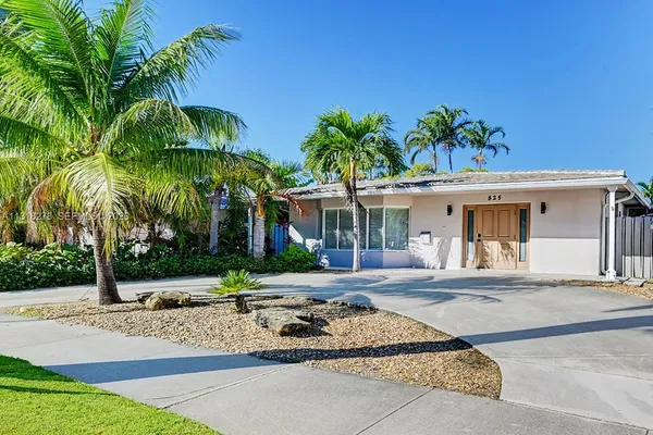 a front view of a house with a garden and patio