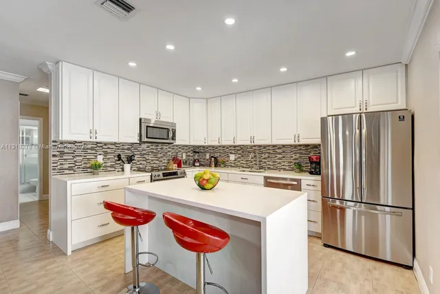 a kitchen with a refrigerator a stove a microwave and island