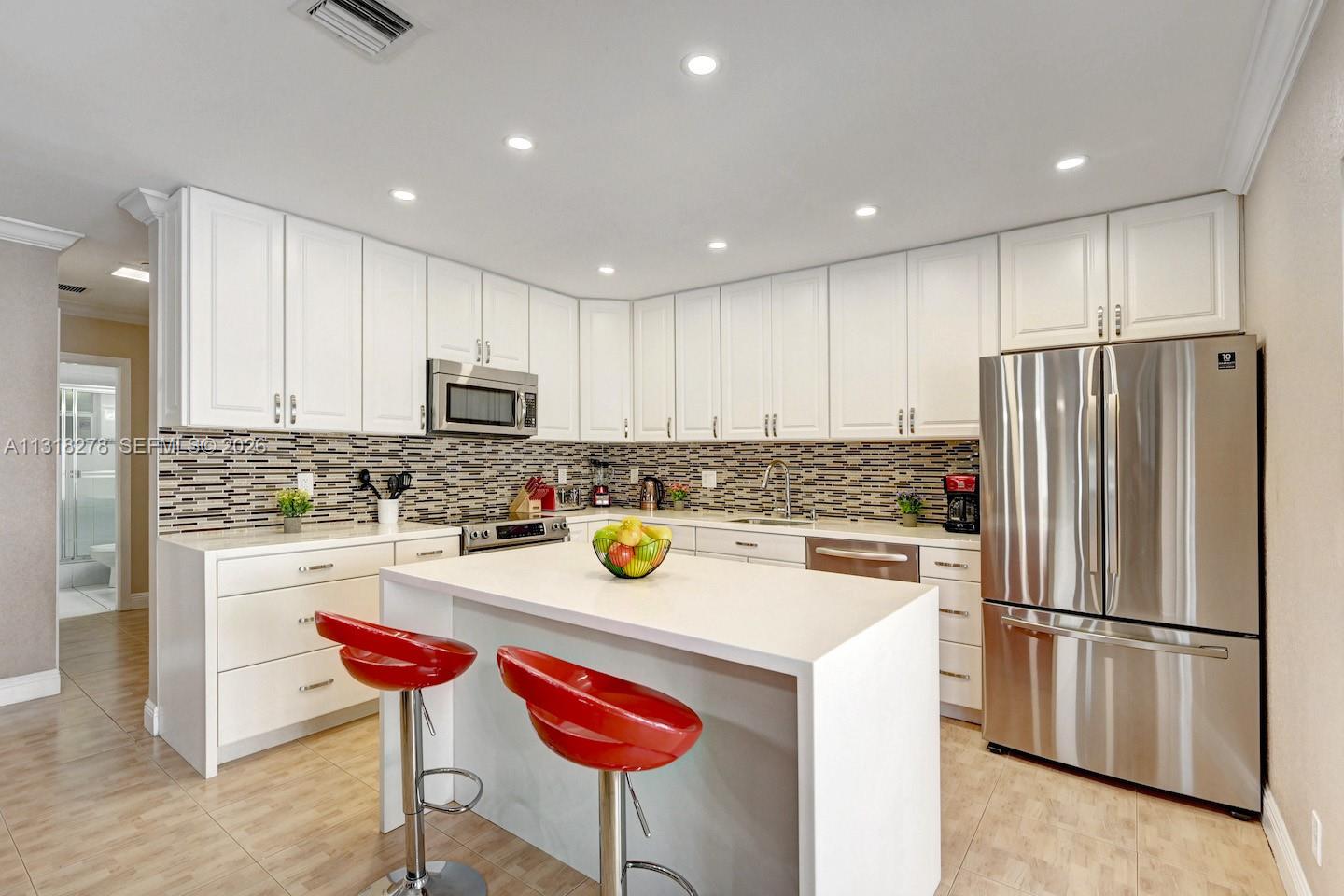 825 Harrison Street Hollywood, FL 33019 - Photo 10 of 37 a kitchen with a refrigerator a stove a microwave and island
