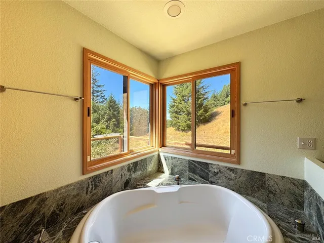 a bathroom with a granite countertop sink and a large mirror next to a window