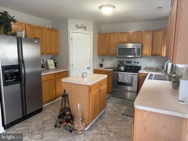 a kitchen with stainless steel appliances granite countertop a sink stove refrigerator and cabinets
