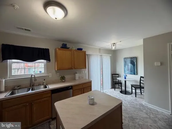 a kitchen with a table chairs sink and cabinets