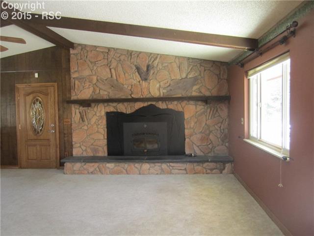 23455 Murphy Road Calhan, CO 80808 - Photo 2 of 5 Great room with vaulted ceiling, wood beams, wood burning fireplace