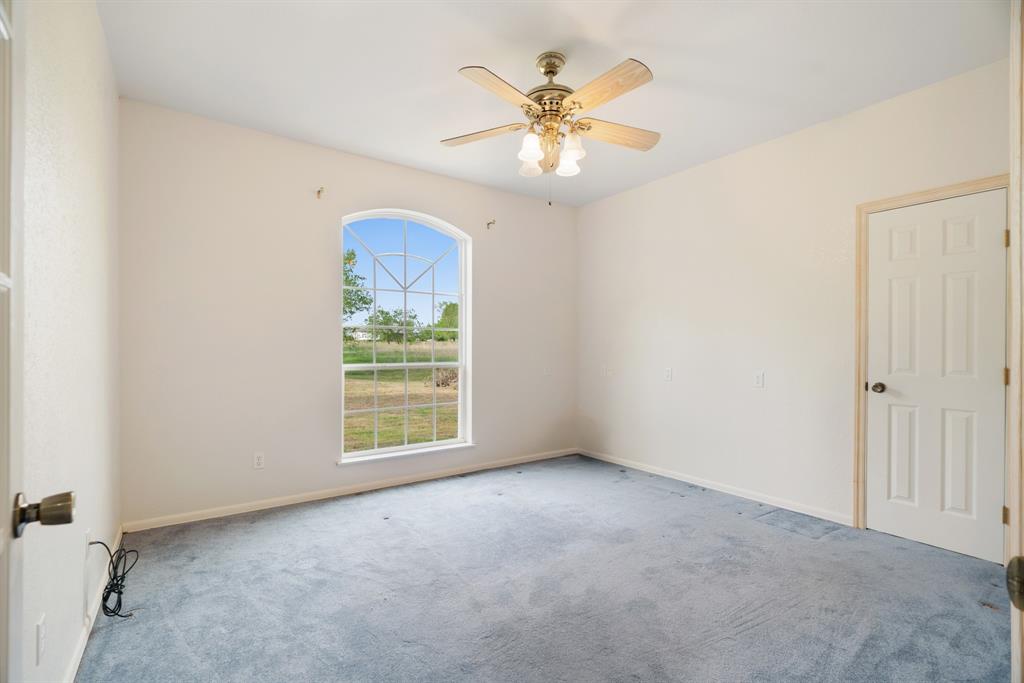 6559 Fm 2068 Commerce, TX 75428 - Photo 26 of 40 an empty room with a chandelier fan and a window
